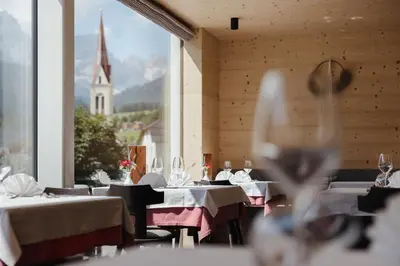 a window with a view of a town and a church at Berghotel Sanví in San Martino in Badia