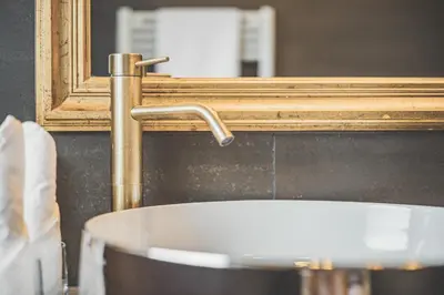 a bathroom with two sinks and a large window at Adults only Hotel Grafenstein in Schenna
