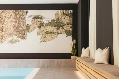 a bedroom with a large painting on the wall at Hotel Boè Sport and Nature in Arabba