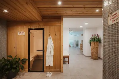 a hallway with a door with a robe on it at Hotel Boè Sport and Nature in Arabba