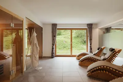 a room with a row of chairs and a large window at Hotel Boè Sport and Nature in Arabba