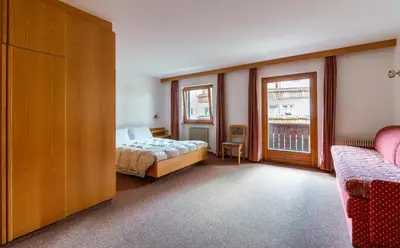 a bedroom with a bed and a window at Apartments Lores in Selva di Val Gardena