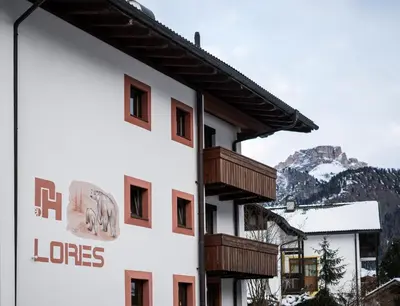 a building with wooden balconies on the side of it at Apartments Lores in Selva di Val Gardena