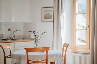 a kitchen with a table with a vase of flowers on it at Ansitz Gurtenhof in Tesimo