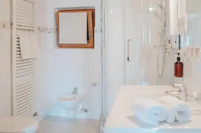 a white bathroom with a sink and a toilet at Ansitz Gurtenhof in Tesimo