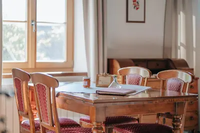 a wooden table with chairs and a box on top at Ansitz Gurtenhof in Tesimo