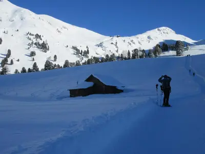 a person on skis in the snow near a cabin at Haus Tannenburg in Funes