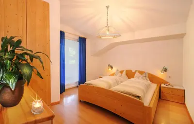 a bedroom with a large wooden bed in a room at Haus Tannenburg in Funes