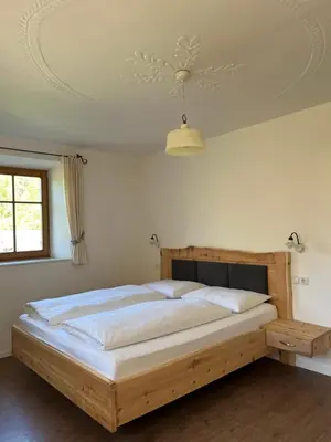 a bedroom with a large wooden bed in a room at Feldererhof in Siusi