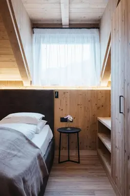 a bedroom with a bed and a window and a table at Alpine Chalet Sauter in San Vigilio Di Marebbe