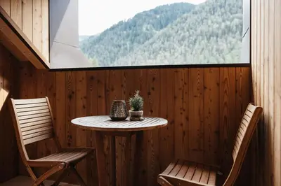 a small table and two chairs in a room with a window at Alpine Chalet Sauter in San Vigilio Di Marebbe
