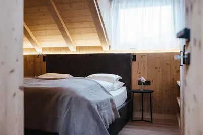 a bedroom with a large bed with a large window at Alpine Chalet Sauter in San Vigilio Di Marebbe