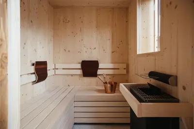 a kitchen with wooden walls and a stove in a room at Alpine Chalet Sauter in San Vigilio Di Marebbe