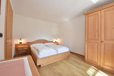 two beds in a small room with a window at Maso Chelò in Cavalese