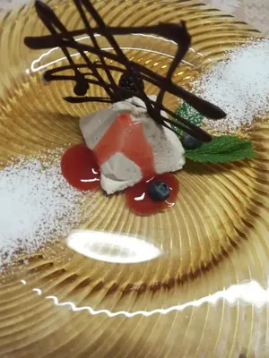 a dessert on a yellow plate with powdered sugar at Park Hotel Arnica in Falcade