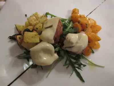 a plate of food with meat and potatoes and vegetables at Park Hotel Arnica in Falcade