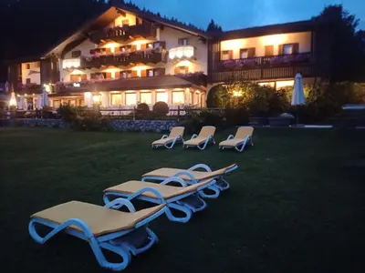 a row of chaise lounge chairs in front of a building at Park Hotel Arnica in Falcade