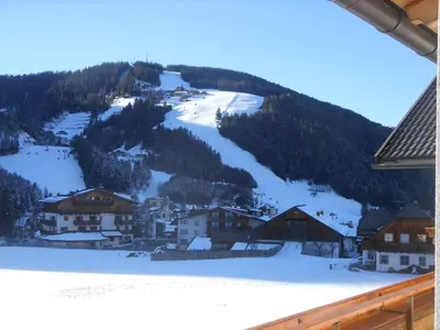 a village in the snow with a mountain at App. Daverda Walter Strada al Plan Dessora 26 in San Vigilio Di Marebbe