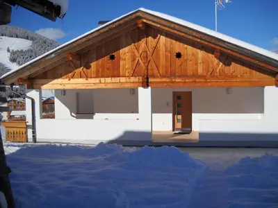 a large white building with a wooden roof at App. Daverda Walter Strada al Plan Dessora 26 in San Vigilio Di Marebbe