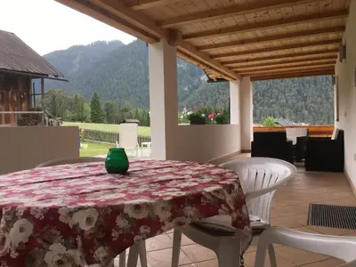 a table with a green vase on it on a patio at App. Daverda Walter Strada al Plan Dessora 26 in San Vigilio Di Marebbe