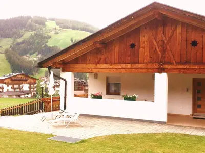 a house with a wooden roof with a patio at App. Daverda Walter Strada al Plan Dessora 26 in San Vigilio Di Marebbe