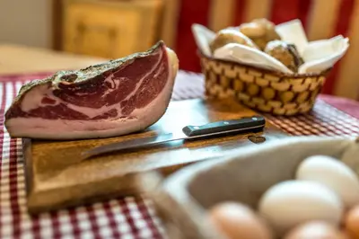 a cutting board with a piece of bread and a basket of eggs at Appartamenti Maierhof in La Valle