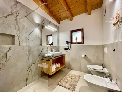 a bathroom with a sink and a toilet at Appartamenti Maierhof in La Valle