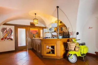 a yellow scooter parked in a room with a counter at Gasthof Goldenes Lamm in Bressanone