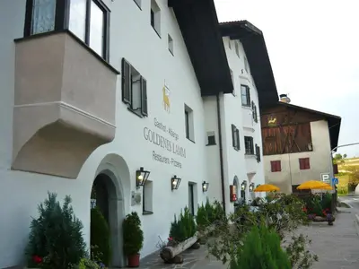 a white building with a sign on the side of it at Gasthof Goldenes Lamm in Bressanone