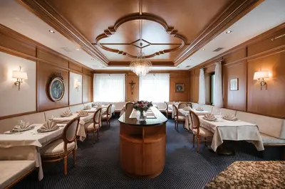 a dining room with tables and chairs and a chandelier at Hotel Isabella in Merano