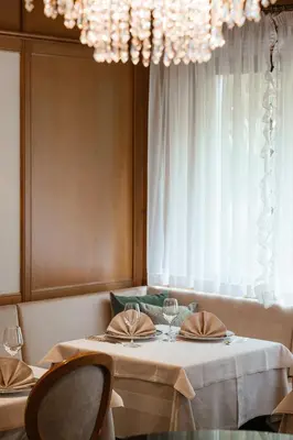 a dining room with a table with chairs and a chandelier at Hotel Isabella in Merano