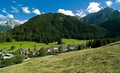 a village on a hill with mountains in the background at Gasthof Huber in Braies