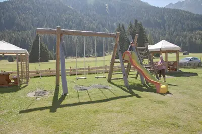 a couple of kids playing on a playground at Gasthof Huber in Braies