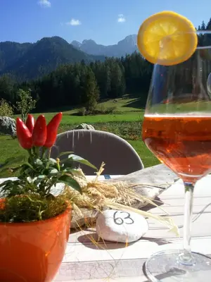 a glass of wine and flowers on a table at Gasthof Huber in Braies