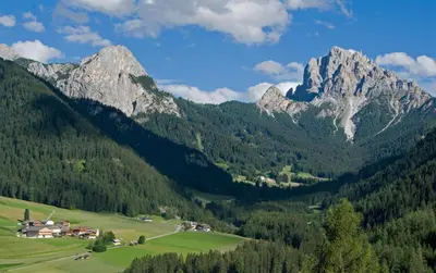 a village in a valley with mountains in the background at Gasthof Huber in Braies