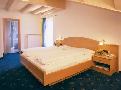 a bedroom with a large wooden bed in a room at Hotel Residence Olympia in Sarntal