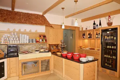 a kitchen with wooden cabinets and red bowls on a counter at Hotel Residence Olympia in Sarntal