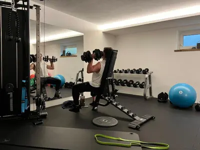 a man is in a gym with weights at Hotel Residence Olympia in Sarntal