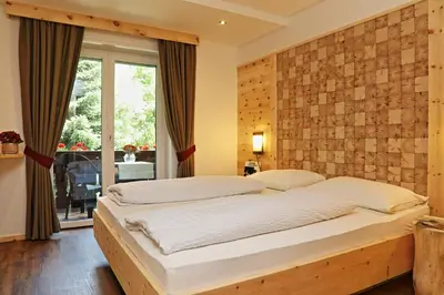 a bedroom with a large bed with a brick wall at Hotel Residence Olympia in Sarntal