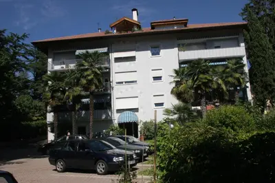 a white building with cars parked in front of it at Residence Atlantic in Merano