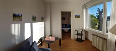 a living room with a couch and a large window at Residence Atlantic in Merano