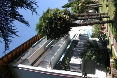 a building with palm trees on the side of it at Residence Atlantic in Merano