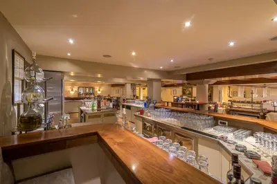 a restaurant with a bar with wine glasses at Taushof in Schenna