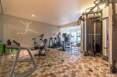 a gym with treadmills and exercise equipment on a wall at Taushof in Schenna