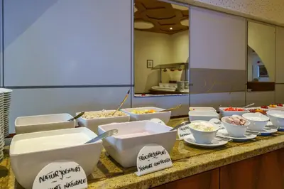 a buffet with bowls of food on a counter at Taushof in Schenna
