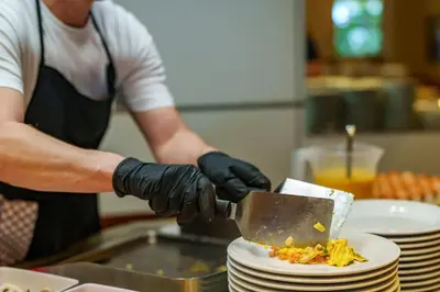 a person in a kitchen preparing food on a plate at Taushof in Schenna