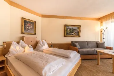a bedroom with a bed and a couch at Taushof in Schenna