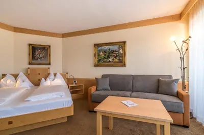a hotel room with a bed and a couch at Taushof in Schenna