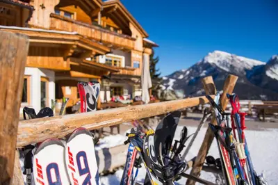 a bunch of skis are leaning against a fence at Rifugio La Para in San Vigilio Di Marebbe