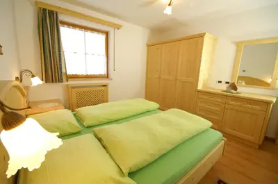 a bedroom with two beds and a sink and a window at Appartamenti Residence Pars in Badia